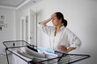© Westend61 - Woman with hand on head standing by drying rack