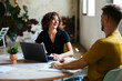 © Westend61 - Happy young businesswoman having discussion with businessman in office