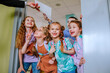 © Westend61 - Hand of teacher giving report card to school children standing in classroom door