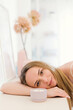 © Westend61 - Smiling woman resting on table next to scented candle