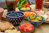 Fototapeta Kuchnia - Stół zastawiony zdrowymi przekąskami w miseczkach i drinkami w szklankach