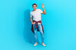 Full size photo of satisfied glad young person put arm pocket palm waving hello isolated on blue color background