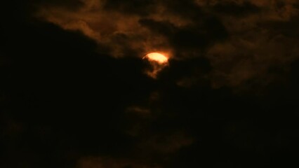 Wall Mural - thick dark clouds move across orange full moon across night sky. static medium
