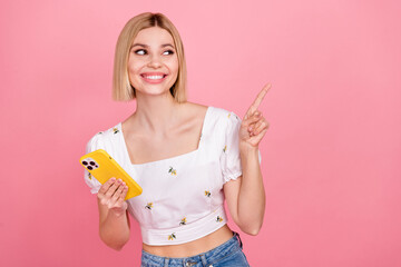Portrait of young lady bob hair wear stylish blouse point finger look empty space smartphone web product isolated on pink color background