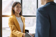 © NINENII - Business men and women shake hands confidently at an office meeting.