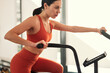 © kegfire - Sportswoman exercising on elliptical trainer in gym