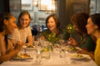 © KOTO - Smiling women friends dining at restaurant table
