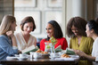 Women friends discussing book club book at restaurant table