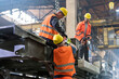 © KOTO - Steel workers fastening crane hook to steel in worker