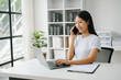 © Nuttapong punna - Happy asian business woman have the joy of talking on the smartphone, tablet and laptopon the office