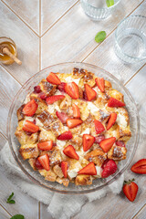 Wall Mural - Strawberry cheesecake French toast casserole with maple syrup. Made with cream cheese and strawberries