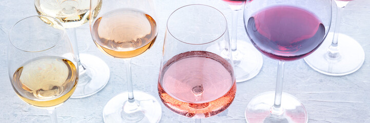 wine glasses at a tasting panorama. rose, red, and white wine, drinks on a table. an assortment of w
