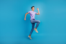 Full Length Portrait Of Excited Young Man In T-shirt Jumping Success Fast Going Over Blue Color Background