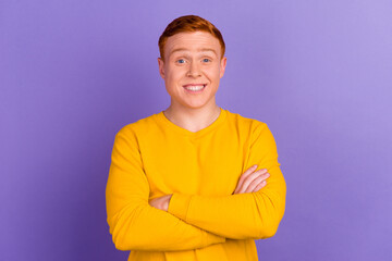 Poster - Portrait of a happy casual man standing with arms folded over violet color background and looking at camera