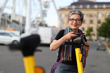 Sticker - A woman rents an electric scooter using an application on her mobile phone.