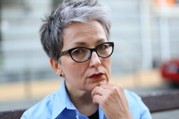 Poster - Portrait of a stylish pensive adult woman in glasses.