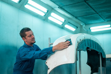 Wall Mural - Caucasian man is cleaning car parts before spraying color in repair mechanic painting shop