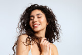 Happy young woman with natural beauty, and beautiful curly hair closed her eyes with pleasure