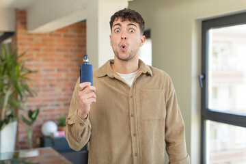 Wall Mural - young handsome man feeling extremely shocked and surprised. vaper smoking concept