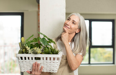 Wall Mural - pretty senior woman smiling with a happy, confident expression with hand on chin. gardener concept