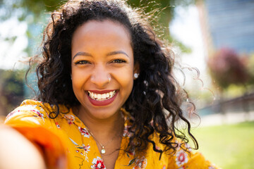 Pretty young african american woman taking selfie outside