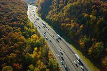 I-40 Freeway In North Carolina Leading To Asheville Through Appalachian Mountains In Golden Fall With Fast Moving Trucks And Cars. Interstate Transportation Concept