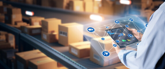 Smart Warehouse,Inventory management system concept.Manager using digital tablet,showing warehouse software management dashboard on blurred warehouse as background