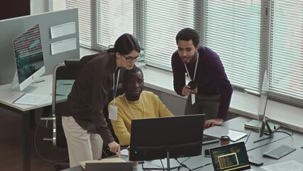 From above shot of group of multiracial programmers discussing software development in modern office
