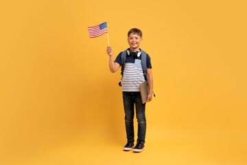 Wall Mural - Happy kid school boy showing flag of the US