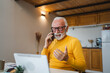 © Miljan Živković - One senior man sit work in tiny house use smart phone make a call