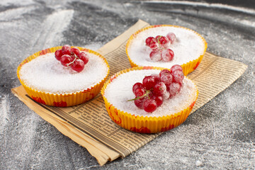 Wall Mural - front close view delicious cranberry cakes with red cranberries on top sugar pieces and powder grey background cake biscuit sweet