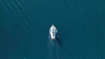 Wall Mural - An aerial view of the sail yacht on the blue sea. Transparent clear water in the sea. Summer vacations and travels on a sailing yacht. Summer relaxation.