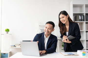 Wall Mural - Smart and professional male manager working with his female assistant. check financial reports Analyze financial data with graph papers and laptop with desk.