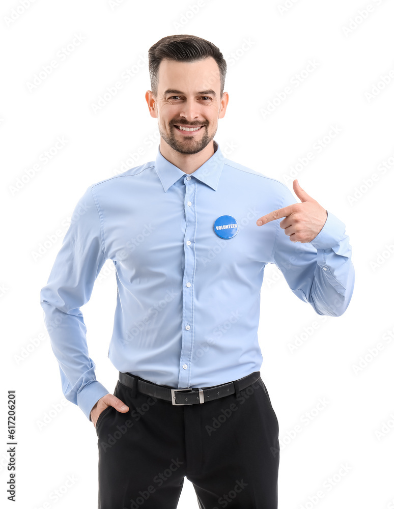 Male volunteer pointing at badge on white background