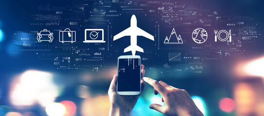 Wall Mural - flight ticket booking concept with a smartphone in blurred city lights at night