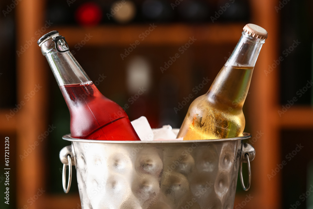 Bucket with bottles of cold beer in bar, closeup