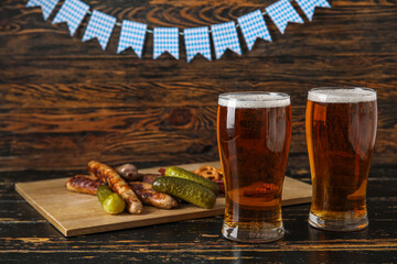 Glasses of cold beer and different snacks on wooden background. Oktoberfest celebration