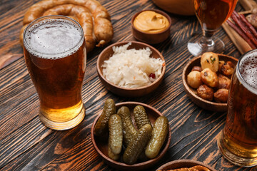 Glasses of cold beer and different snacks on wooden background. Oktoberfest celebration