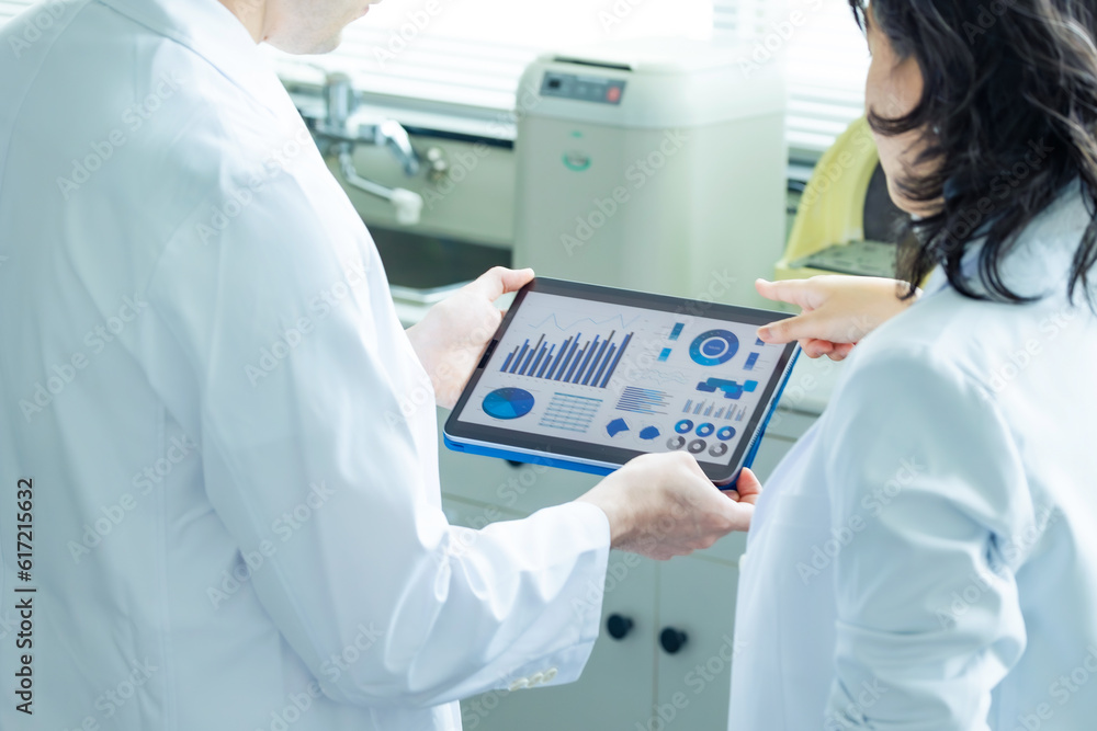 Group of researchers looking at tablet data in the lab. Research and ...