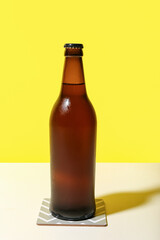 Bottle of cold beer on yellow background