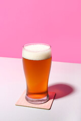 Glass of cold beer on color background