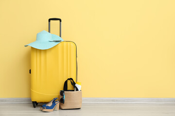 Wall Mural - Suitcase with passport and beach accessories on yellow background. Travel concept