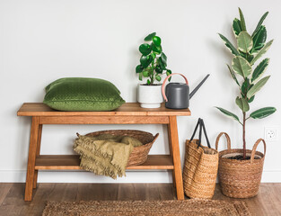 Bedroom interior with oak bench, pillow, blankets, homemade flowers and watering can. Cozy house concept