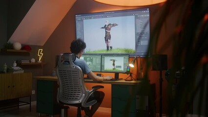 Young 3D designer creates animation for video game character, works remotely from home late night on computer and big digital screen with professional software interface for 3D modeling and design.