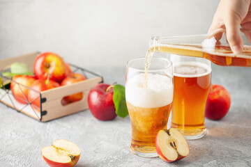 Wall Mural - Boozy Refresing Cold Hard Apple Cider in a Pint Glass and Bottle on wooden table. Copy space