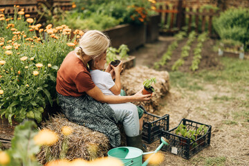 Back view of a woman sitting in the garden with her child.