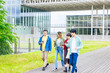 Multinational youth group walking with smart phone in college campus. College students.