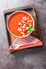 Poster - Spanish tomato soup gazpacho with strawberries, cucumbers and basil close-up in a bowl on the table. Vertical top view from above