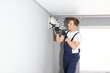 © Serhii - handsome young man electrician installing air conditioning in a client house