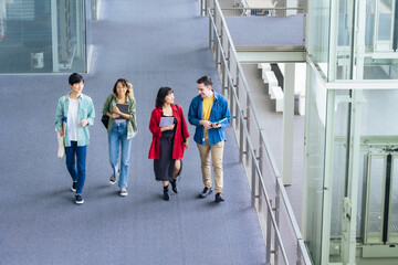 Poster - Multinational youth group walking in building. College students. High angle view.